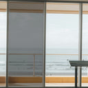 Simulated: Solar Gard Sentinel Plus Stainless Steel Exterior Window Film, Stainless Steel 25% Dark, on the left window panel next to clear glass